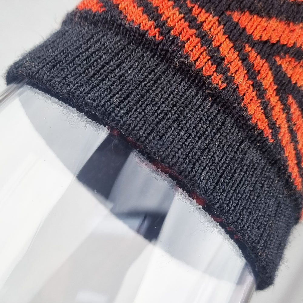 Close-up of a sock with black and orange pattern on a white background